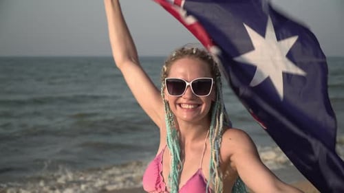 Woman Waving Flag on a Sunny Beach