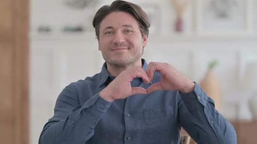 Smiling Man Making Heart Shape with Hands