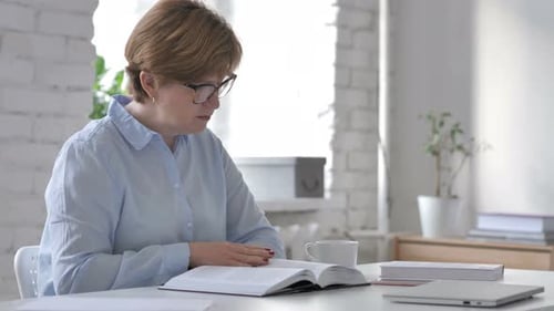 Old Woman Reading Book in Office
