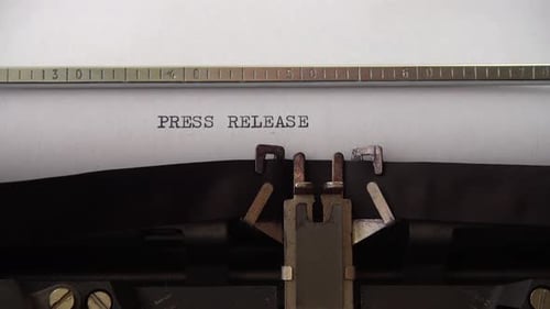 Typing phrase Press Release on retro typewriter. Close up.