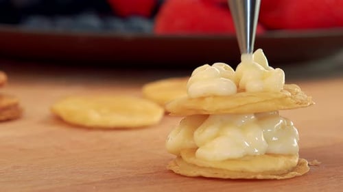 A Woman Makes a Dessert Out of Phyllo Pastry Rounds and Cream, a Plate of Fruits