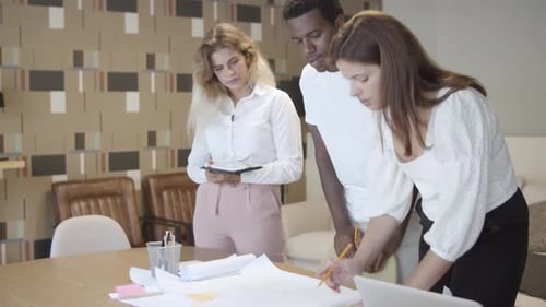 Team Discussing Plans at Office Table