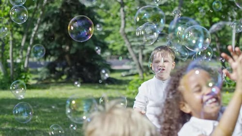 Happy Kids Playing in Park at Bubble Show