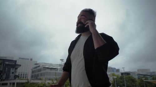 Man Celebrates Good News on Mobile Phone in City