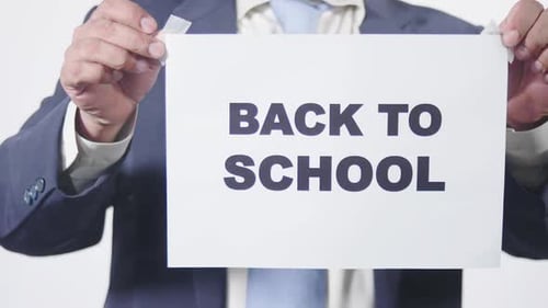 Businessman Posts Sign On Window Back To School