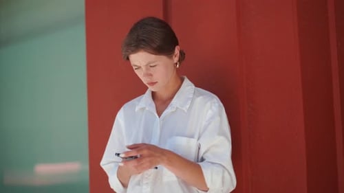 Young Woman Using Phone Against Colorful Wall