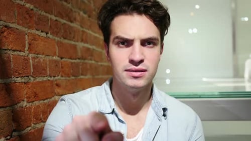 Serious Young Adult Pointing Directly at the Camera