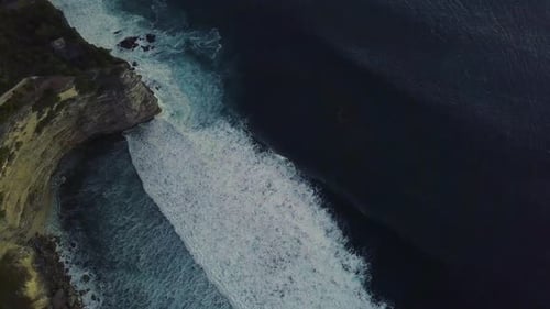 De majestueuses vagues de surf blanches se déplaçant et se brisant dans l'océan bleu.