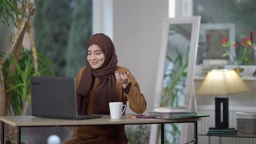 Young Woman Works on Laptop During a Video Call
