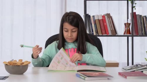 Girl Studying at Desk Writing in Workbook