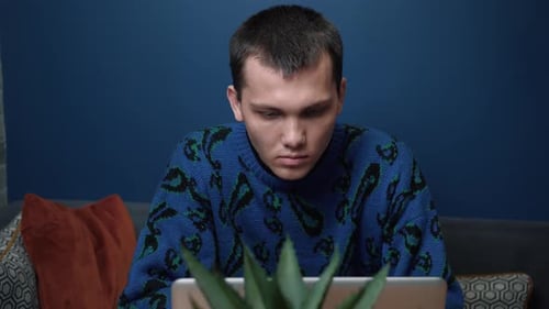 Young Adult Using Laptop on Sofa Close Up