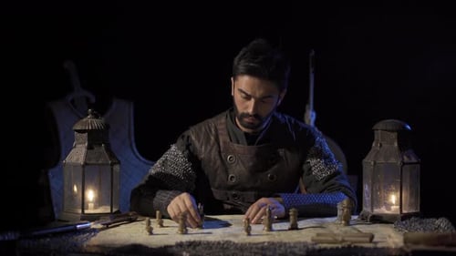 Man in Armor Strategizes with Chess at Night