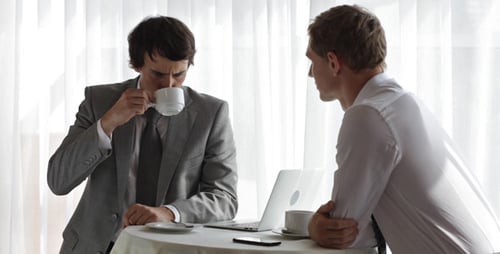 Two Men Meeting at a Table Drinking Coffee
