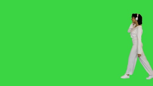 Happy African American Lady Walks Listening To Music on a Green Screen Chroma Key
