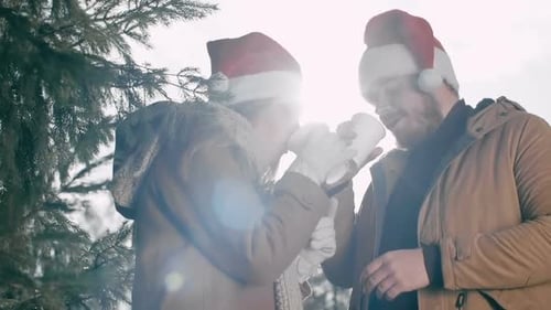 Couple Drinking Hot Beverage in Winter Wonderland