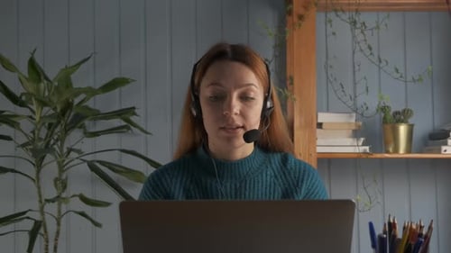 Woman Using Laptop and Headset for Online Meeting