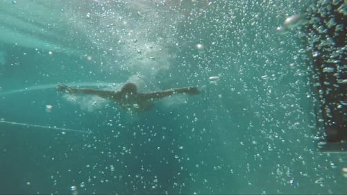 Bubbles Underwater und Man in Red Kurzschwimmen