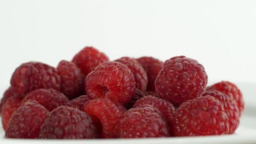 Eco bright colorful berry raspberry rotates 360 on a white background. Close-up of loose raspberry