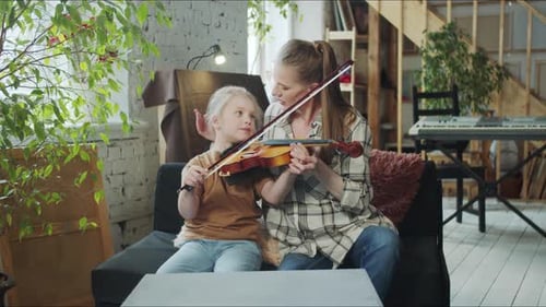 Woman Teaching Young Girl to Play Violin at Home