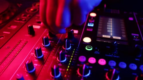 Closeup fingers of sound engineer tuning fader on mixing console. DJ adjusts volume on equipment