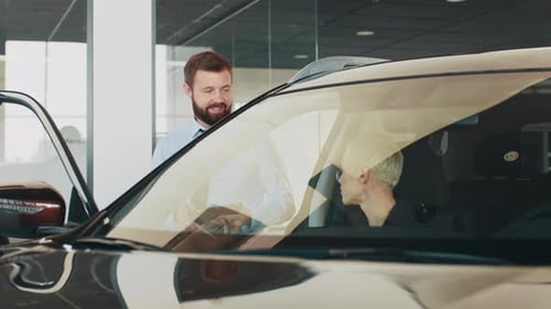 Cheerful Car Salesman Assisting Woman in Dealership