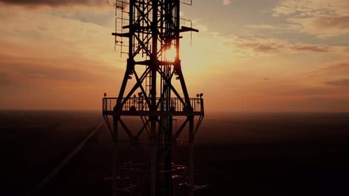 High Broadcasting TV Tower with Large Antenna at Sunset