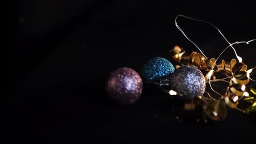 Christmas decorations and lights on a black background close up panning shot
