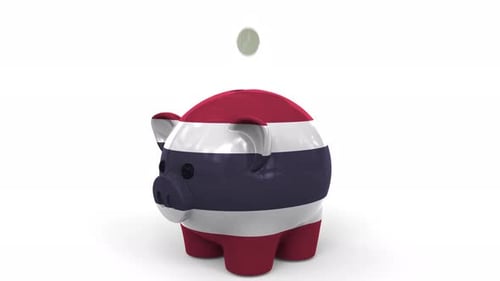 Coins Fall Into Piggy Bank Painted with Flag of Thailand
