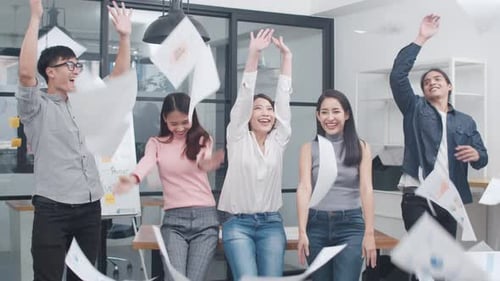 Group of Asia young creative people wear celebrate project success and throwing documents in office.