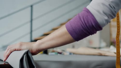Woman Rolls Out Fabric and Marks Pattern
