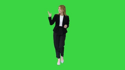 Female Presenter Blond Woman Walking and Pointing To the Sides on a Green Screen, Chroma Key.