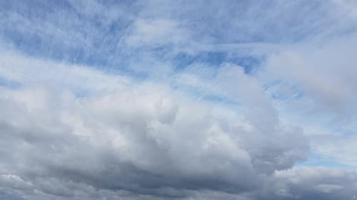 Dramatic White Clouds Moving Slowly Across Blue Sky