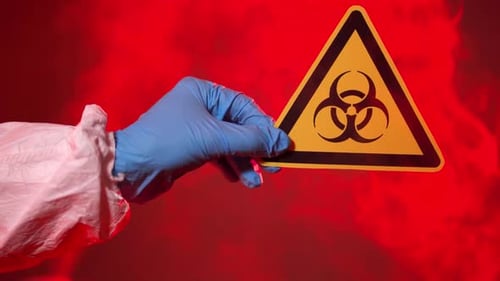 The Doctor Holds a Biohazard Sign in the Coronavirus Infection Area