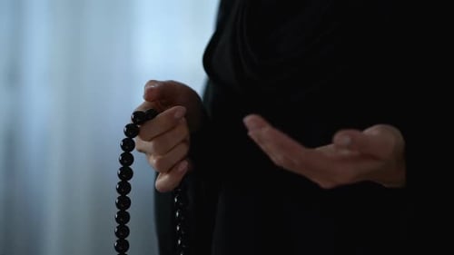 Muslimische Frau betet mit islamischen Perlen in der Hand, religiöse Meditation, Gottesdienst
