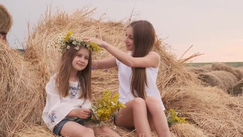 Girls on Hay Bales with Wildflower Crowns