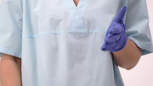 Person in Scrubs Using Hand Sanitizer