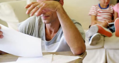 Tense man checking bills in living room
