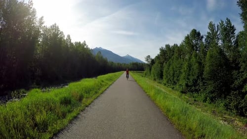 Woman riding unicycle on countryside road 4k