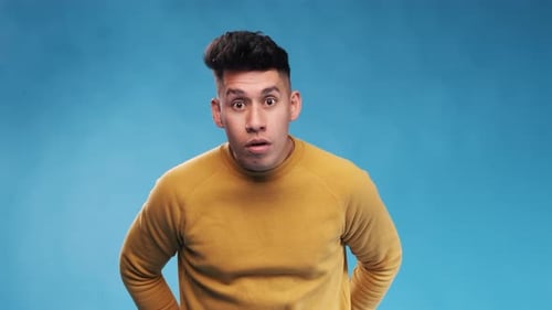 Young Man Looks Surprised on Blue Background