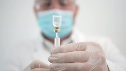 Medical Professional Drawing Liquid into Syringe