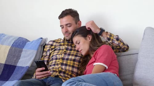 Loving Couple Relaxing at Home with Smartphone
