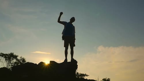 Silhouette of Young Adult Celebrating Mountain Peak Success