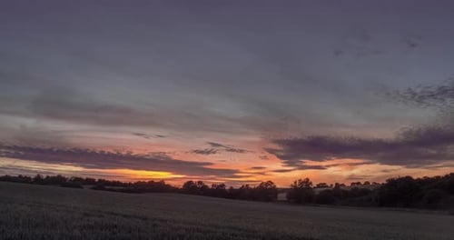 Rural Field at Sunset with Orange Sky