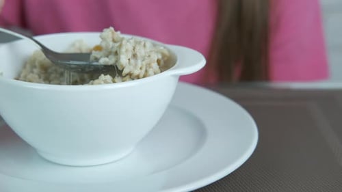 Girl eat oatmeal.