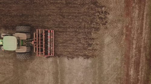 a Large Tractor Plows a Field