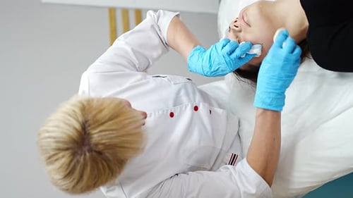 Woman Getting Facial Cleansing Procedure in Clinic