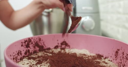 Adding Cocoa Powder to Mixing Bowl for Baking