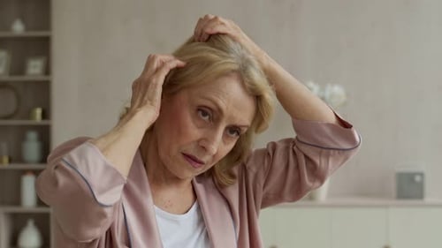 Woman Checks Her Hair in Her Home