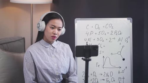 Female Explains Science Equations to Camera at Home