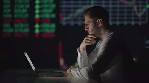 Man Watching Stock Market Data on Laptop